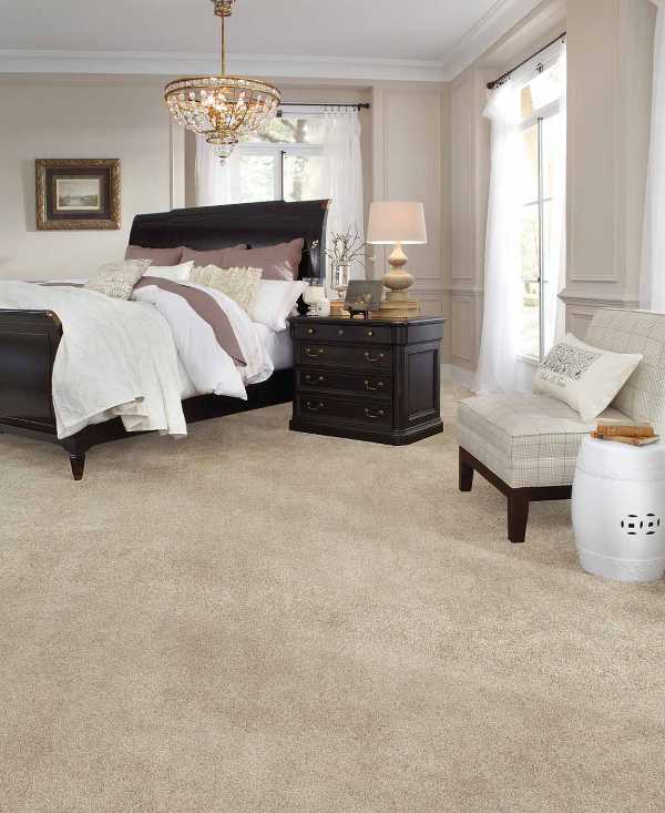 traditional bedroom with elegant light fixture large bed and beige carpet